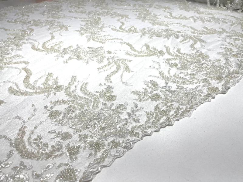 Ivory flowers embroider and heavy beaded on a mesh lace fabric-sold by the yard.