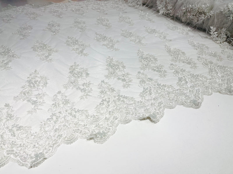 White elegant hand beaded flower design embroider on a mesh lace-prom-sold by the yard.