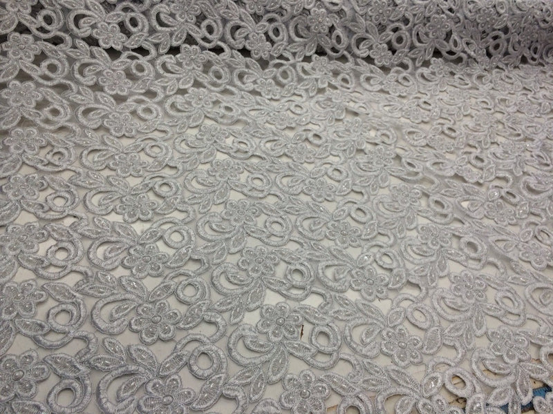 Silver metallic flowers embroider and hand beaded organza lace.36x50inches. Sold by the yard.