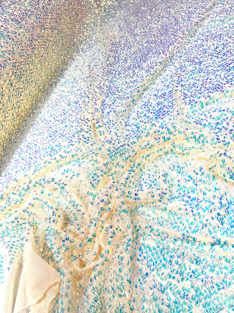 Aqua Clear iridescent mini round paillette sequins on a nude stretch mesh, sold by the yard.