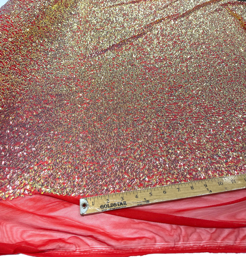 Aqua Clear iridescent mini round paillette sequins on a red stretch mesh, sold by the yard.