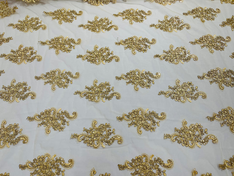 Gold metallic floral design embroidery on a mesh lace with sequins and cord-sold by the yard.
