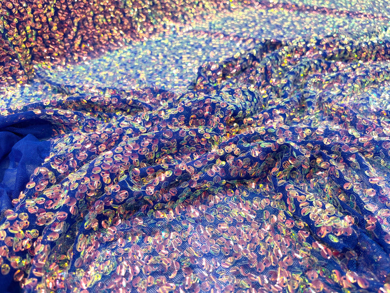 Aqua Clear iridescent mini round paillette sequins on a royal blue stretch mesh, sold by the yard.