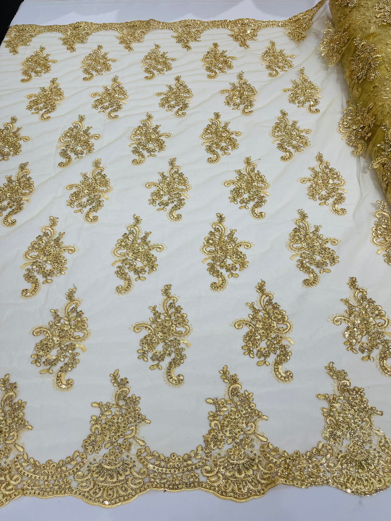 Gold metallic floral design embroidery on a mesh lace with sequins and cord-sold by the yard.