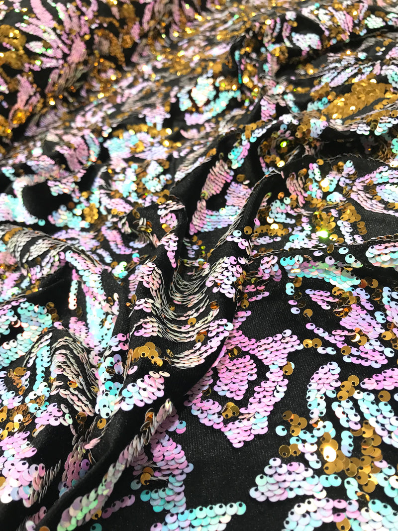 Aqua iridescent ,pink, gold  sequins flip two tone floral design on a black stretch velvet, Sold by the yard.